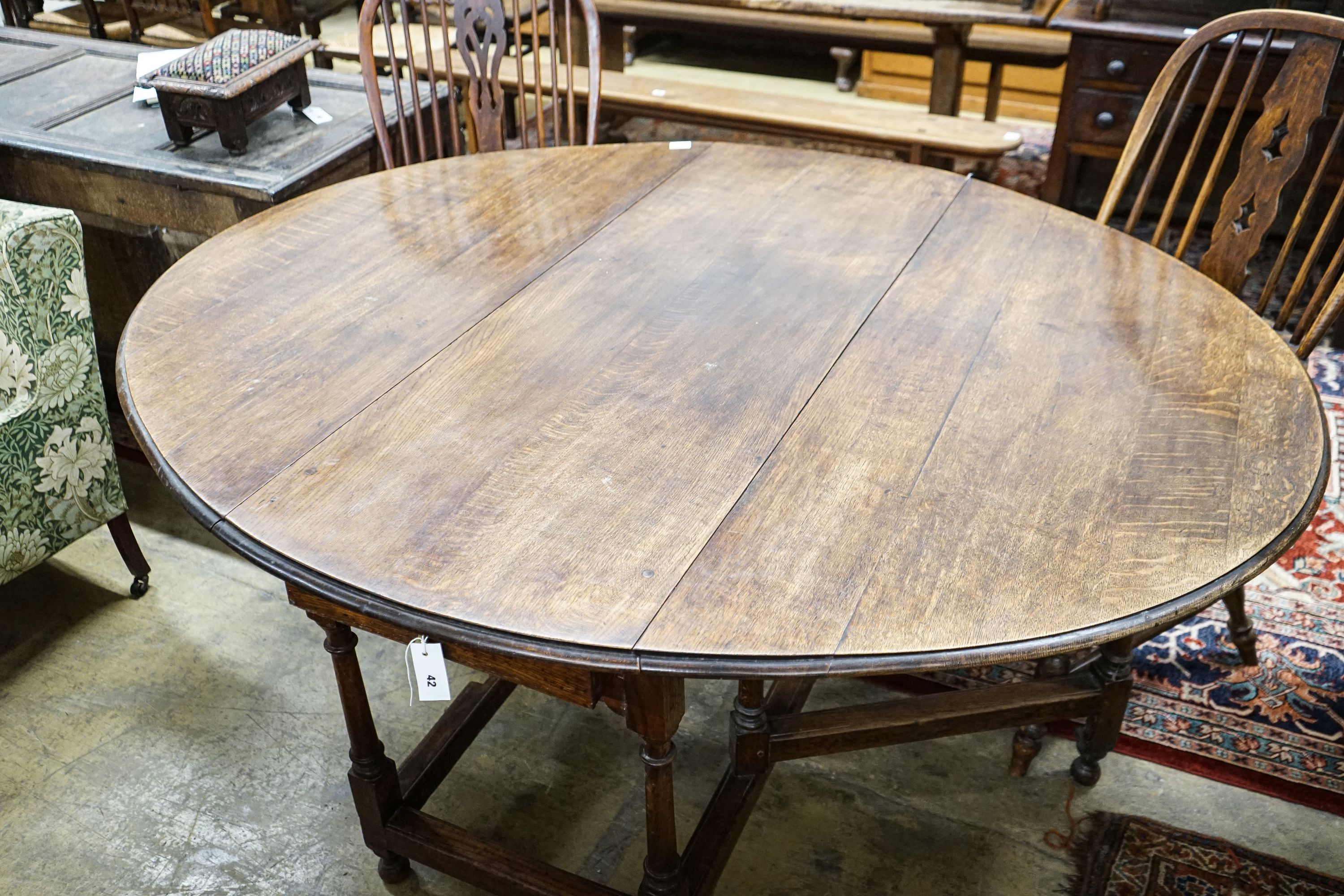 A 17th century style oak gateleg table, with oval top and two frieze drawers, open to 170cm, width 148cm, height 73cm